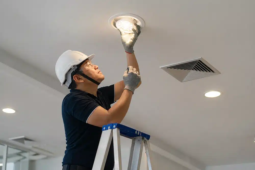 Cara Memilih Lampu Pengganti untuk Gedung yang Sudah Beroperasi 1 Teknisi mengganti lampu